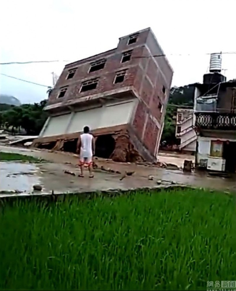 惊险：广西楼房暴雨后轰然躺倒 男子围观全程