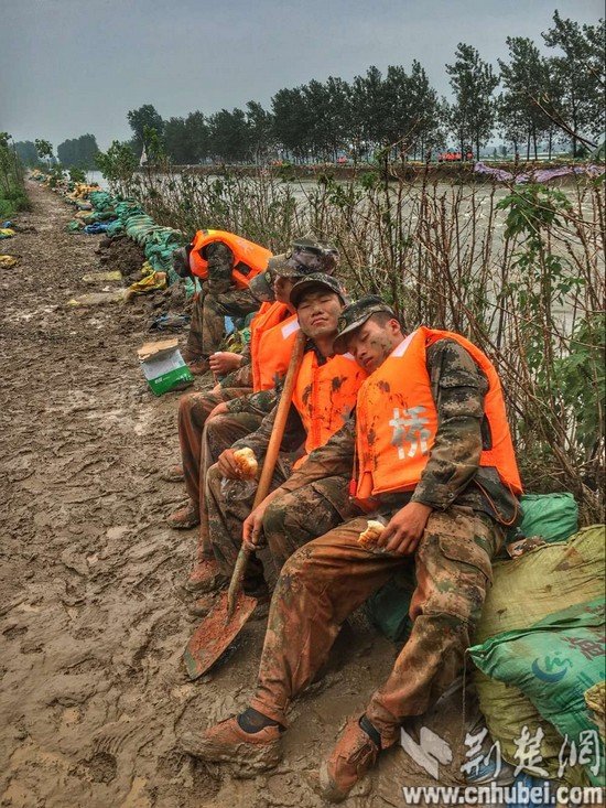 连续奋战25小时 舟桥旅官兵拿着面包睡着了(组图)