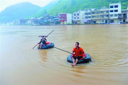 湖北乐观灾民 将轮胎当船在雨中捕鱼作乐(图)