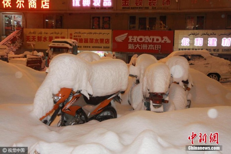 新疆阿勒泰迎大雪天气 街头车辆被雪埋 (组图)